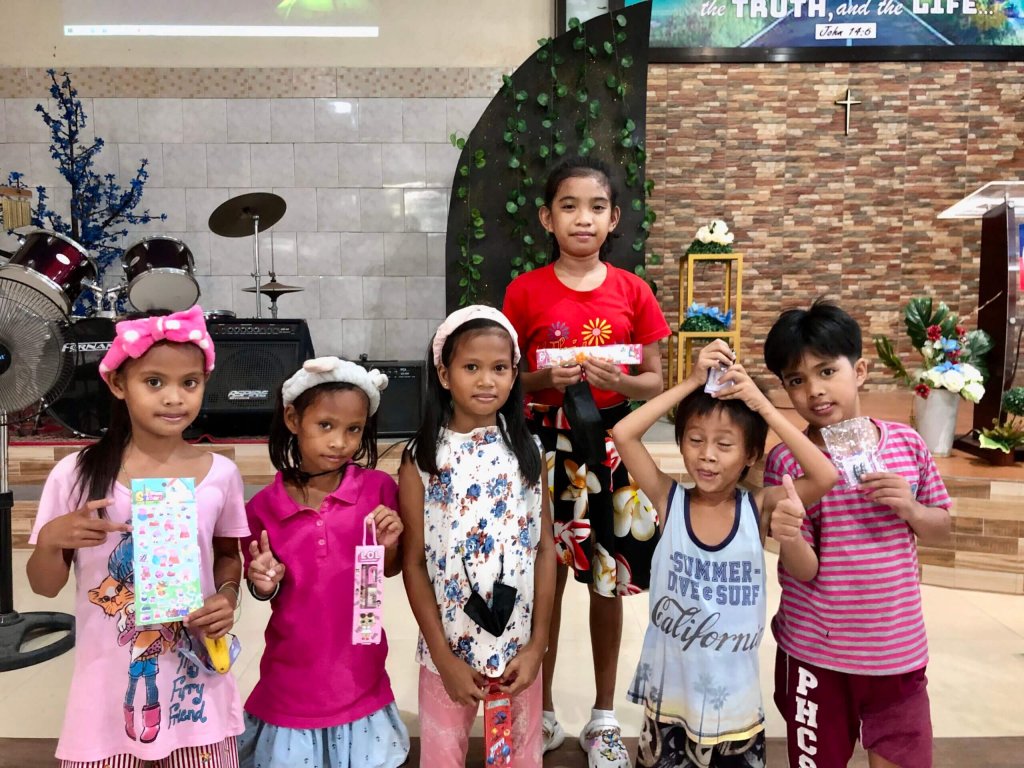 Group of children holding gifts and smiling